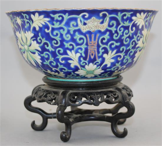 A Chinese blue ground porcelain bowl, Qianlong mark, late 19th / early 20th century, 21.5cm diam., wood stand